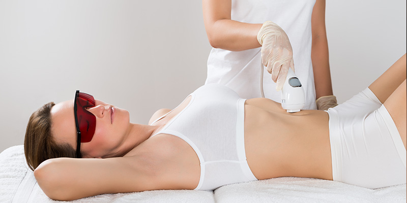 Woman having her stomach hair removed by female beautician. Laser epilation  treatment. close up Stock Photo | Adobe Stock